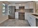 Updated kitchen with stainless steel appliances, white cabinets, and stone tile backsplash at 117 N Garfield Ave # 16, Deland, FL 32724