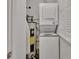 This laundry area includes a stacked washer and dryer, water heater and window with closed blinds at 117 N Garfield Ave # 16, Deland, FL 32724