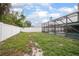 Spacious backyard with white fence and screened-in lanai at 1369 Saxon Blvd, Deltona, FL 32725