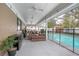 Covered patio with outdoor seating area adjacent to a refreshing swimming pool at 1369 Saxon Blvd, Deltona, FL 32725