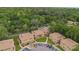 Aerial view of the condo complex surrounded by lush landscaping, and mature trees at 140 Orchid Woods Ct # 14B, Deltona, FL 32725