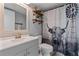 Bathroom featuring a modern vanity, toilet, and shower-tub combo with decorative shower curtain and floating shelves at 140 Orchid Woods Ct # 14B, Deltona, FL 32725