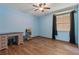 Cozy bedroom features a large window with wood floors and a blue accent wall at 140 Orchid Woods Ct # 14B, Deltona, FL 32725