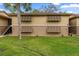 Two-story condo featuring awning-style window covers and well-maintained lawn in a residential community at 140 Orchid Woods Ct # 14B, Deltona, FL 32725