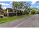 A view of condo complex with screened in porch and lush green lawn and mature trees at 140 Orchid Woods Ct # 14B, Deltona, FL 32725
