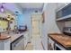 A well-lit kitchen area that has stainless steel appliances, a sink, and a tiled wall with white cabinets at 140 Orchid Woods Ct # 14B, Deltona, FL 32725
