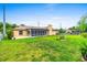 Expansive backyard with lush green grass, partial fencing, and a charming enclosed patio at 1426 Saxon Blvd, Deltona, FL 32725