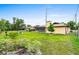 Spacious backyard featuring a large lawn, screen enclosure, and mature trees at 1426 Saxon Blvd, Deltona, FL 32725