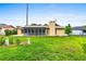 Backyard featuring a landscaped lawn with a screened-in patio and mature tree at 1426 Saxon Blvd, Deltona, FL 32725