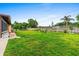 Spacious backyard featuring lush green grass, partial fencing, and mature trees at 1426 Saxon Blvd, Deltona, FL 32725