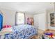 The bedroom has a white closet, a large window, and a decorative blue patterned bedspread at 1479 Renton St, Deltona, FL 32725
