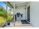 The covered front porch has a chair, plants, and a welcome mat at the front door at 1479 Renton St, Deltona, FL 32725