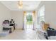 This sunroom has tile flooring, a ceiling fan, and sliding glass doors to the backyard at 1479 Renton St, Deltona, FL 32725