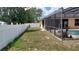 A fenced backyard features a screened in pool area and grass at 1491 E Palomar Dr, Deltona, FL 32738