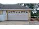 Spacious white garage door with decorative windows and exterior lighting at 1491 E Palomar Dr, Deltona, FL 32738