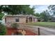 A brick home featuring a gravel driveway and mature trees at 1491 E Palomar Dr, Deltona, FL 32738