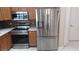 Kitchen featuring stainless steel appliances, wood cabinets, backsplash, and stone countertops at 1491 E Palomar Dr, Deltona, FL 32738