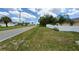 Street view of a home with a lush green lawn and white picket fence under a sunny sky with scattered clouds at 1491 E Palomar Dr, Deltona, FL 32738