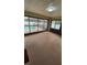 Screened-in sunroom with an outdoor pool view and neutral carpeted flooring at 1491 E Palomar Dr, Deltona, FL 32738