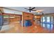 Cozy living room boasts a stone fireplace, wood floors, and an open layout connecting to the kitchen at 160 Rose Ave, Lake Helen, FL 32744