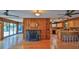 Open-concept living area with wood flooring, fireplace, and adjacent kitchen at 160 Rose Ave, Lake Helen, FL 32744