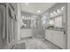 Elegant bathroom features dual vanities, marble tile floors, a glass-enclosed shower, and modern lighting at 173 Old Moss Cir, Deland, FL 32724