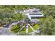 Aerial view of a charming clubhouse surrounded by lush landscaping and a circular driveway at 173 Old Moss Cir, Deland, FL 32724