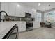 Modern kitchen equipped with stainless steel appliances, white cabinetry, and stylish mosaic backsplash at 173 Old Moss Cir, Deland, FL 32724