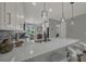 Spacious kitchen boasting white cabinets, quartz countertops, stainless steel appliances, and a mosaic tile backsplash at 173 Old Moss Cir, Deland, FL 32724