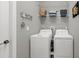 Functional laundry room with a full-size washer, dryer, and overhead shelving for added storage at 173 Old Moss Cir, Deland, FL 32724