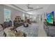 Spacious living room featuring gray walls, a large area rug, tray ceiling and modern furnishings at 173 Old Moss Cir, Deland, FL 32724