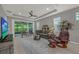 Bright living room with large windows, neutral paint, fan, and a comfortable seating arrangement at 173 Old Moss Cir, Deland, FL 32724