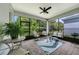 Cozy screened patio with brick flooring, a ceiling fan, and views of the landscaped backyard at 173 Old Moss Cir, Deland, FL 32724