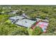 Aerial view showcasing multiple tennis courts surrounded by lush greenery and trees at 173 Old Moss Cir, Deland, FL 32724
