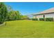 Expansive backyard featuring lush green grass, mature trees, and a screened-in patio with pool at 1855 Cattle Creek Ln, Port Orange, FL 32128
