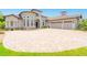 Elegant home featuring a circular driveway, stone accents, arched windows, and a three-car garage at 1855 Cattle Creek Ln, Port Orange, FL 32128