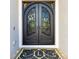 Elegant arched, wrought iron double doors with glass inserts and custom monogrammed welcome mat at 1855 Cattle Creek Ln, Port Orange, FL 32128