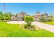 Well-manicured front lawn of this elegant home, complete with an American flag, beautiful landscaping, and a circular driveway at 1855 Cattle Creek Ln, Port Orange, FL 32128