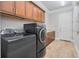 Well-equipped laundry room with wood cabinets, countertops, and modern, black appliances at 1855 Cattle Creek Ln, Port Orange, FL 32128
