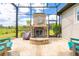 Covered outdoor patio featuring a stone fireplace with chairs, offering an elegant outdoor living space at 1855 Cattle Creek Ln, Port Orange, FL 32128