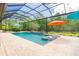 Inviting pool with tanning ledge, poolside seating, and lush landscaping in a screened-in enclosure at 1855 Cattle Creek Ln, Port Orange, FL 32128