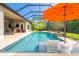 Stunning screened-in pool with a tanning ledge, outdoor kitchen, and poolside seating at 1855 Cattle Creek Ln, Port Orange, FL 32128