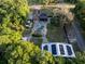 Aerial view of the home displaying the backyard pool, landscaping, and solar panels in a lush green environment at 1899 W Beresford Ave, Deland, FL 32720