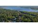An aerial view of the property showcasing a scenic, wooded landscape with a tranquil lake in the background at 1899 W Beresford Ave, Deland, FL 32720