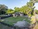 Aerial view of the house, large yard, pool, covered outdoor living area and surrounding trees at 1899 W Beresford Ave, Deland, FL 32720