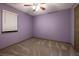 Bedroom with purple walls, neutral carpet, and a window with blinds at 1899 W Beresford Ave, Deland, FL 32720