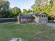 Charming two-story home with stone accents, an American flag, and solar panels on the roof at 1899 W Beresford Ave, Deland, FL 32720