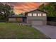 Charming two-story home with green lawn, stone accents, gray siding and a paved driveway at 1899 W Beresford Ave, Deland, FL 32720