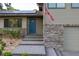 Charming home featuring stone accents, solar panels, a blue front door, and manicured landscaping at 1899 W Beresford Ave, Deland, FL 32720