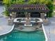 Close-up of a swim-up bar with a pergola and submerged chaise lounges in the pool at 1899 W Beresford Ave, Deland, FL 32720